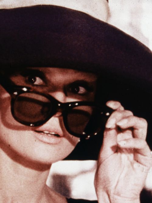 Audrey Hepburn mit schwarzem Hut und Sonnenbrille.