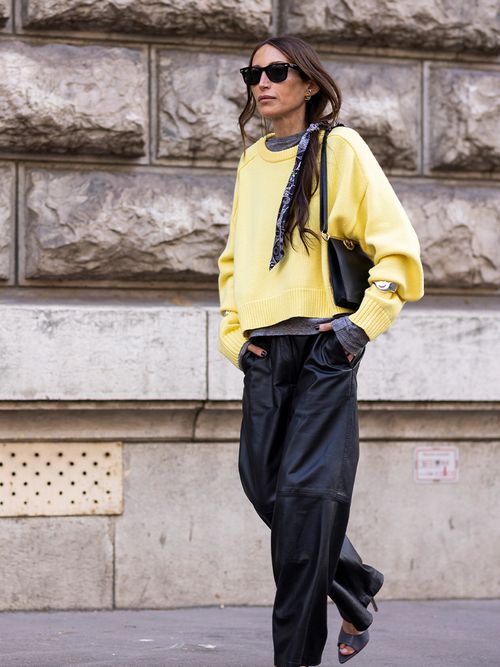 Influencerin Chloe Harrouche trägt einen gelben Pullover und schwarze Lederhosen mit Sonnenbrillen bei der Paris Fashion Week