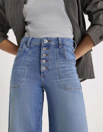 River Island Jeans a fondo ampio di colore medio con tasche sul davanti-Blu