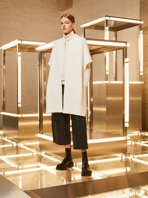 Model mit schwarzer Culotte und einem weißen Strickoberteil