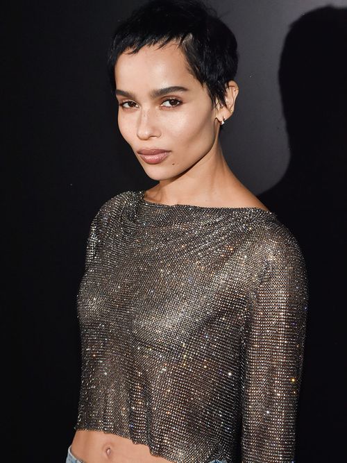 Zoe Kravitz mit einem cropped Top aus einem Glitzerstoff und einem kurzen Pixie Cut.