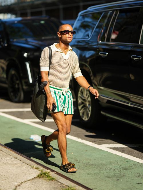 Street Style Look von der New York Fashion Week, wo ein Gast ein Poloshirt mit Badeshort, Totebag und Sandalen trägt.