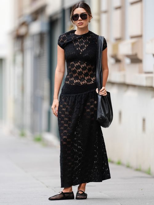 Katie Giorgadze trägt ein schwarzes langes Spitzenkleid mit schwarzer Brille und Mesh Schuhe in Paris.
